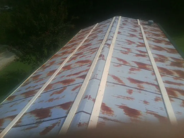 Rusted metal roof panels with new wood purlins before replacement — Storm Damage Roof Repair in Friesland by Roofing Brothers